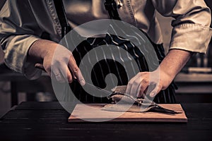 Chef cutting the fish on a board