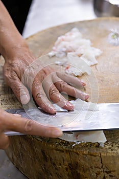 chef cutting fish in a kitchen vertical composition