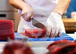 Chef cutting fresh tuna fish in the kitchen