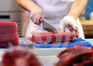 Chef cutting fresh tuna fish in the kitchen