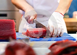 Chef cutting fresh tuna fish in the kitchen