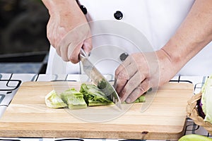 Chef cutting green lettuce