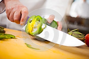 Chef cutting a green pepper