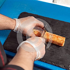 Chef cutting the Kani sushi hot roll