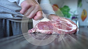 Chef Cutting Meat. Man Cuts Fresh Meat Standing at Table in Kitchen in Bright House. Man Holding Knife in Hand. Food