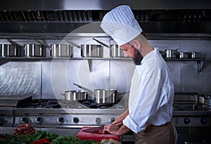 Chef cutting meat in restaurant kitchen
