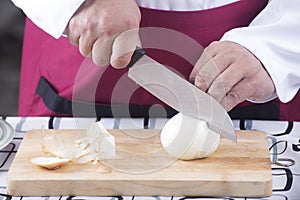 Chef cutting onion with knife