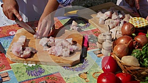 Chef cutting raw fish on a wooden chopping board