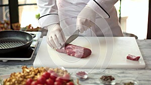 Chef cutting raw meat.