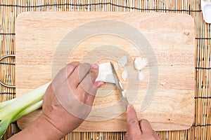 Chef cutting scallion on wooden broad