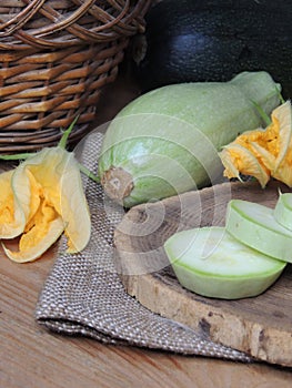 chef cutting zucchini on wooden board in home kitchen
