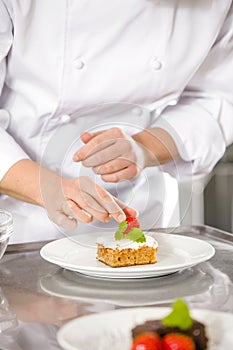 Chef decorate dessert cake with strawberry