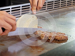 Chef Deliberately Preparing and Cooking Traditional Teppanyaki on Hot Plate