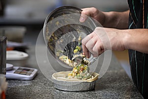 chef filling a vegetable tart photo