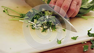 Chef finely chopping herb leaves; closeup