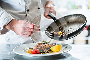 Chef finishing food in his restaurant kitchen