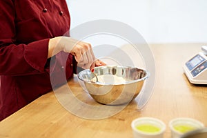 Chef with flour in bowl making batter or dough