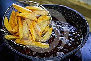 A chef frying French fries in a pan