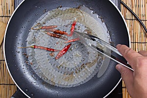 Chef frying red dried chlli in the pan