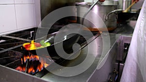 Chef frying vegetables in a wok and adding ladle of water