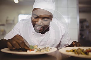 Chef garnishing meal on counter