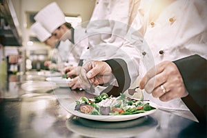 Chef garnishing salads photo