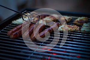 Chef grilling sausage on flame