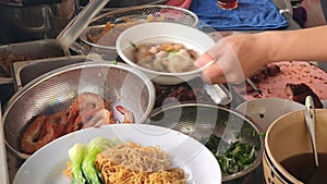 Chef hand making wonton noodles soup at restaurant \'s kitchen, mi hoanh thanh bowl