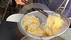 Chef hand making wonton noodles soup at restaurant \'s kitchen, mi hoanh thanh bowl