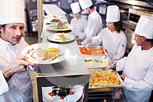 Chef handing dinner plates through order station