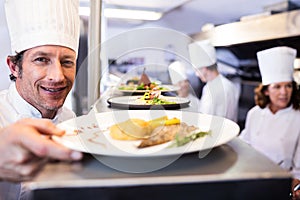 Chef handing dinner plates through order station