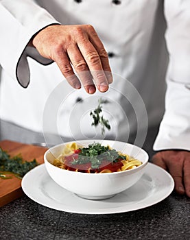 Chef, hands and bowl with pasta recipe in kitchen for fine dining, serving or cooking at restaurant. Closeup of person