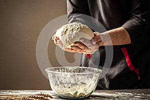 Chef hands cooking dough on dark wooden background. space for text