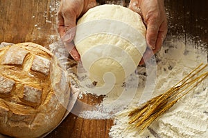 Chef hands with dough and homemade natural organic bread and flour