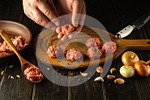 The chef hands form meatballs from ground beef. Concept of preparing a meat dish at brunch