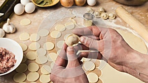 Chef hands forming small handmade dumplings on kitchen