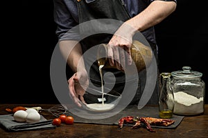 Chef hands are pouring milk from terracotta jar to prepare dough