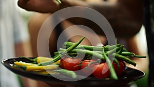 Chef hands putting vegan food on grill outside. Plate with grilled vegetables