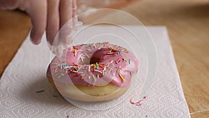Chef hands sprinkle pink donut powder