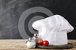 Chef hat with salt, pepper and tomato