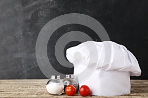 Chef hat with salt, pepper and tomatoes