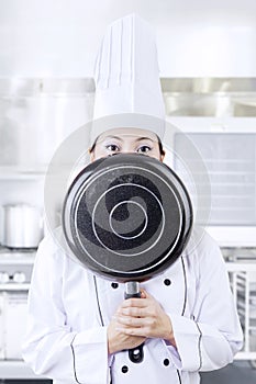 Chef hiding her face with a pan