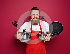 Chef hold a lot of pots. concept of stress and confusion. red background