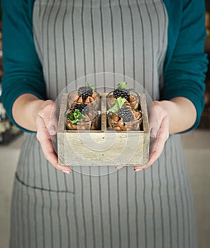 Chef holding chocolate dessert with blackberry