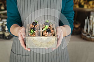 Chef holding chocolate dessert with blackberry