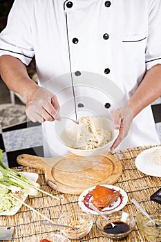 Chef holding the noodle from the bowl with fork