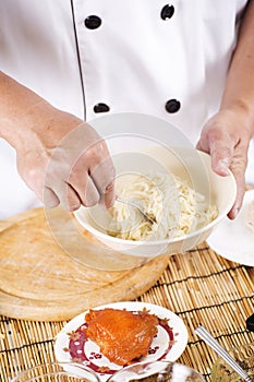 Chef holding the noodle from the bowl with fork