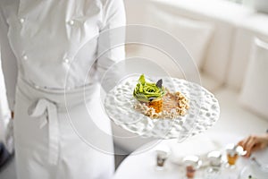 Chef holds a plate with delicious vegetarian meal at restaurant