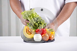 Chef holds tray of vegetable