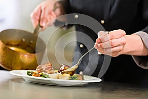 Chef in hotel or restaurant kitchen cooking